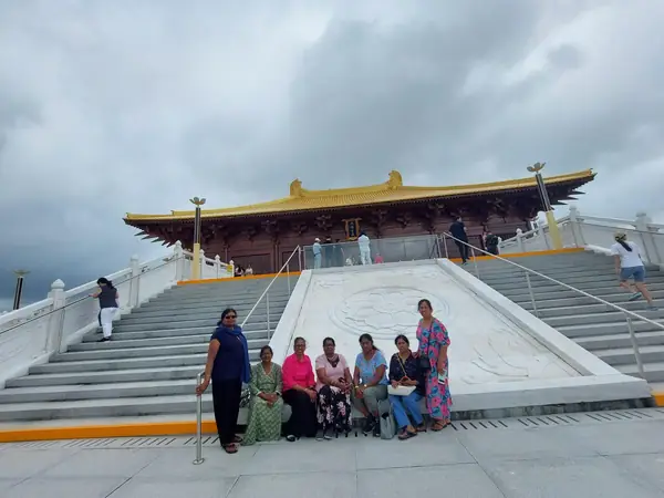 Small group posing at the foot of steps leading to a large temple building