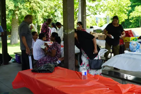 People gathered at tables in a park