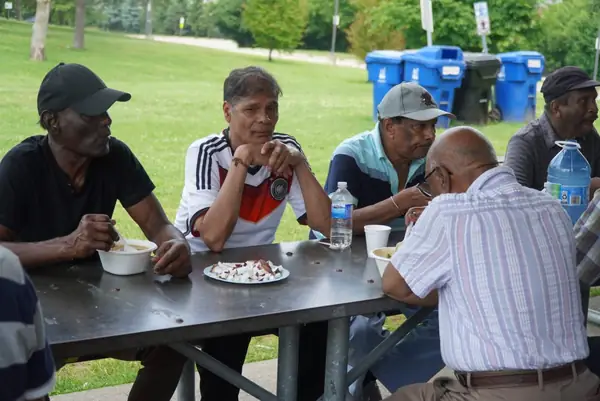 People sharing a meal at an outdoor picnic table