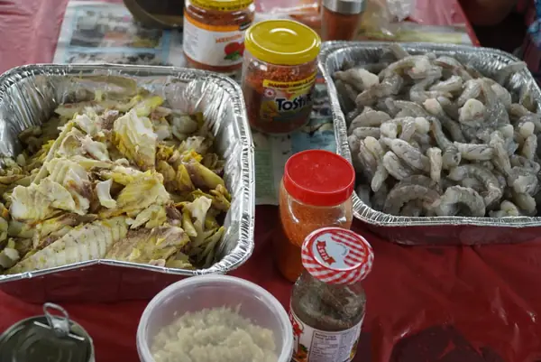 Trays of food and condiments on a picnic table