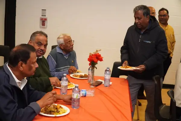 People seated at a table with food indoors