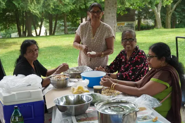 People gathered around a picnic table with food