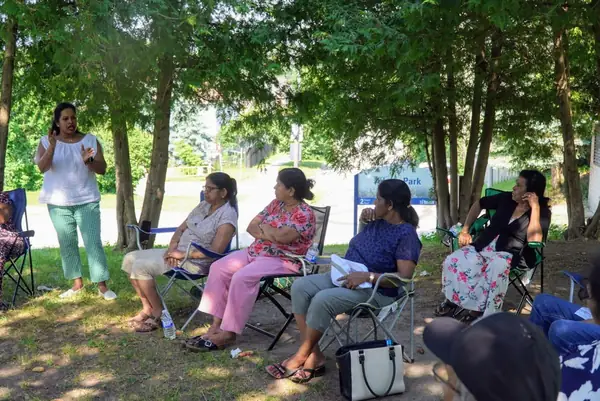 People seated in lawn chairs in a park