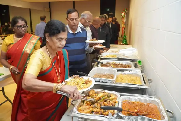 A woman in a sari serving herself from a buffet