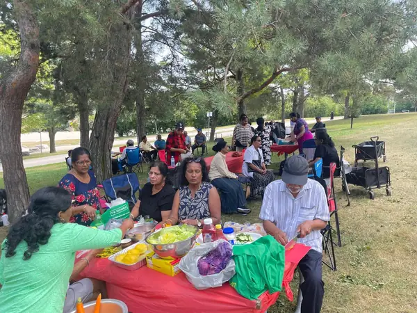People gathered around a table of food outdoors