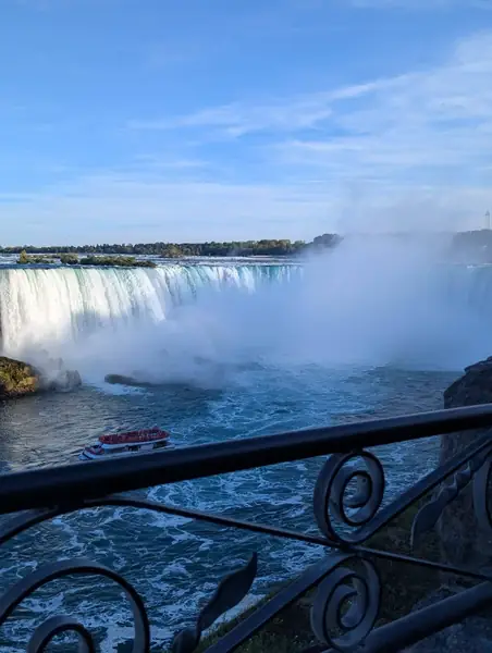 View of a waterfall and mist from behind a railing