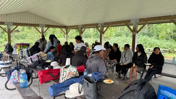 People seated under a large pavilion