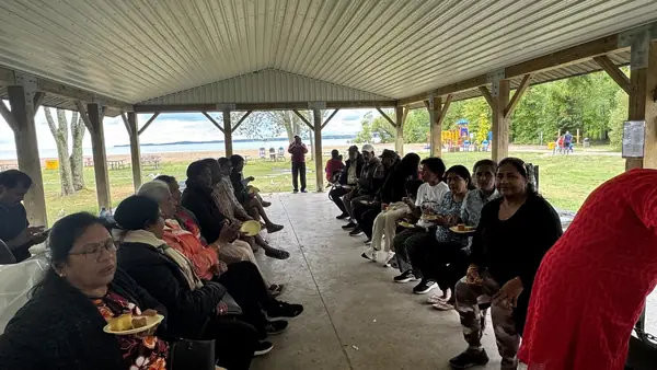 People seated under a large pavilion