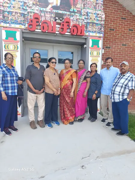 Group posing in front of a colourfully decorated temple entrance