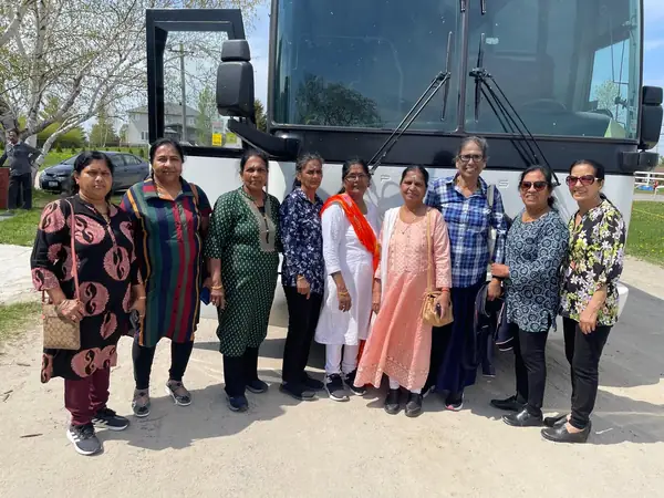Group posing in front of a tour bus