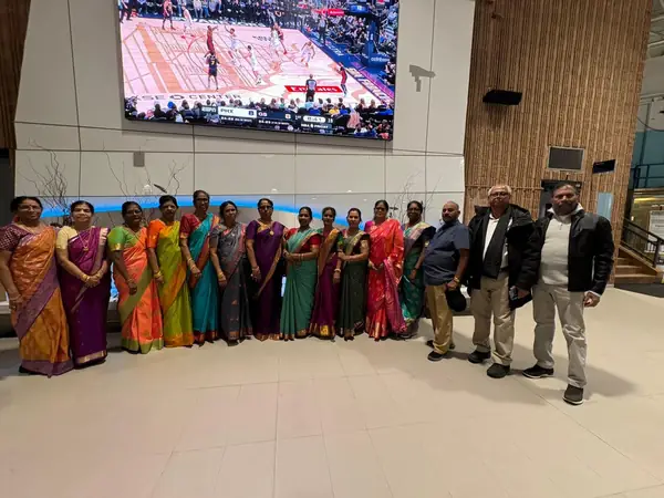 Large group posing in front of a screen in a hall