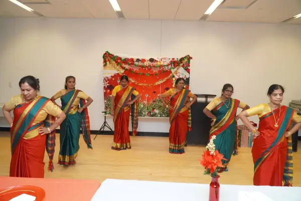 Women in saris performing in a hall