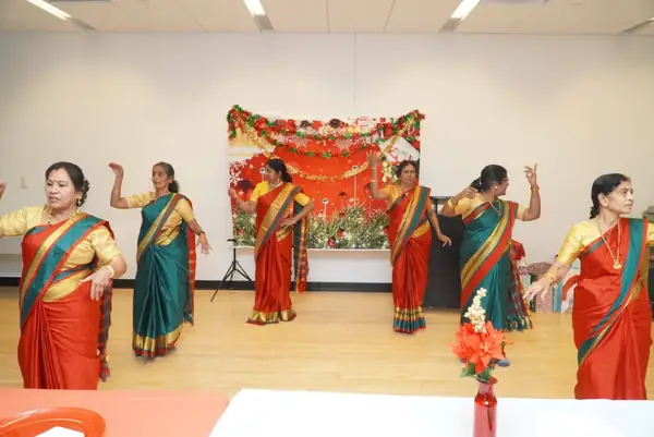 Women in saris performing in a hall