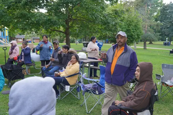 People seated in lawn chairs in a park