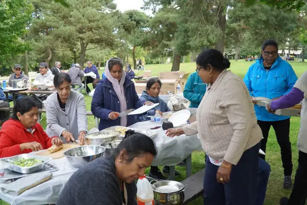 People gathered at a picnic table with food