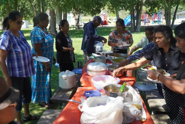 People gathered around a picnic table with food