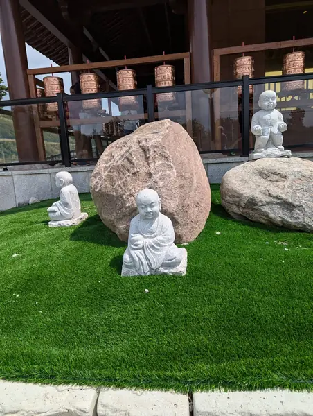 Garden with small white statues and large stones