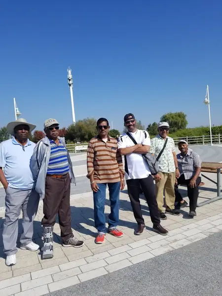 Group of men posing outdoors under a blue sky