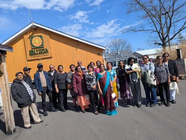 Group posing in front of a wooden building