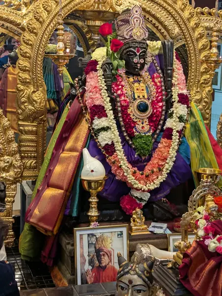 Decorated deity statue adorned with flower garlands