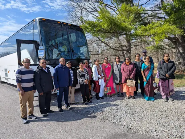Group posing in front of a tour bus