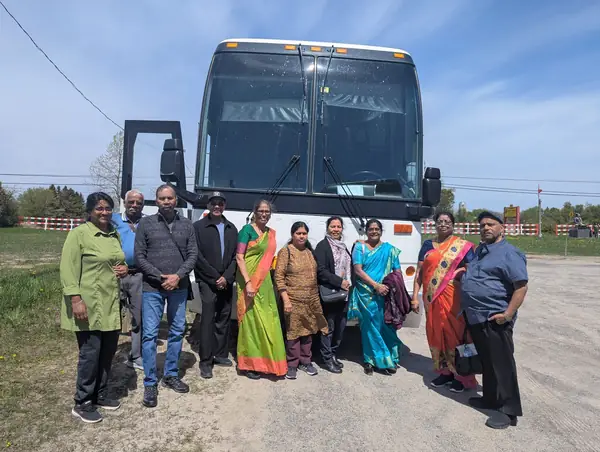 Group posing in front of a tour bus