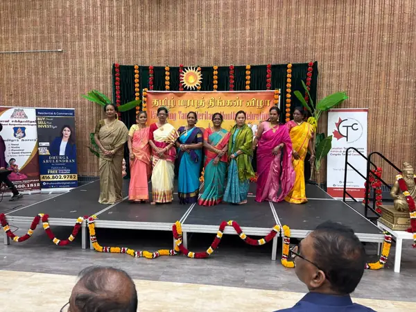 Group posing on a stage under a banner