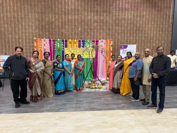 Group posing in front of a colourful decorated backdrop